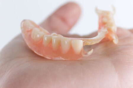 flexible nylon denture on female hand. Removable dentures flexible, devoid of nylon, hypoallergenic exempt from monomer